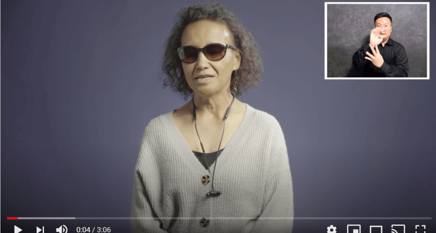 a snapshot of the video with a blind woman speaking and a certified deaf interpreter at the top right.